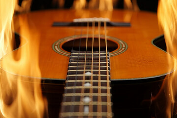 Fototapeta premium Jazz music Acoustic guitar with bright orange flames engulfing the body fire