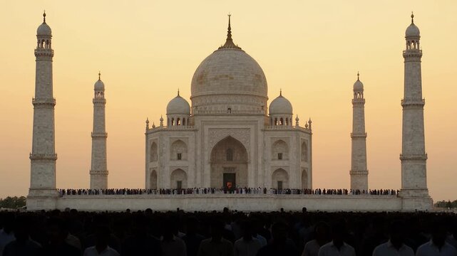 The taj mahal at sunset with a large crowd of people gathered in front of it in agra india