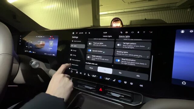 A driver uses a touchscreen in a modern car.
