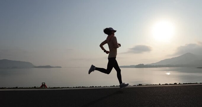 Fitness woman runner running at seaside