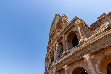 Fototapeta premium Famous tourist attraction of historic Colosseum amphitheatre with ancient stone arches in Rome Italy