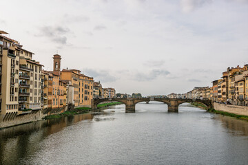 Fototapeta premium Famous historic Ponte Vecchio bridge and old buildings along the Arno river in Florence Italy