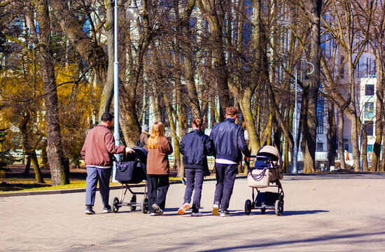 Belarus.Minsk, Two married couples with strollers on a walk in the park
