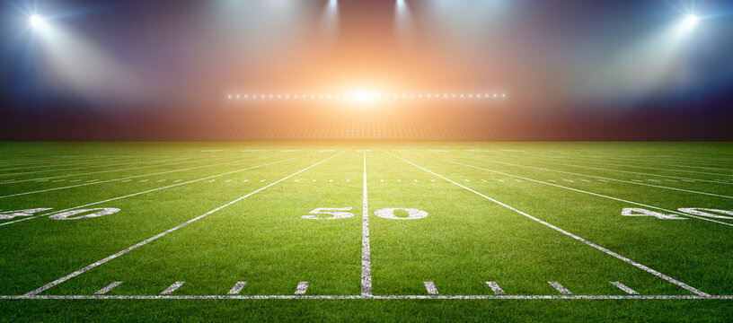 American football stadium field with bright lights.