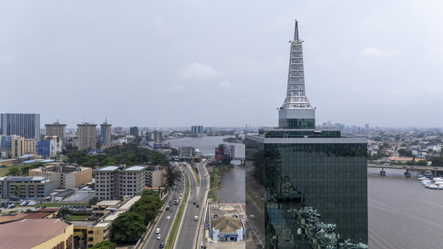 Lagos, Nigeria - 02 August 2025: Aerial view of the Civic Centre towers majestically against the Lagos skyline, its glass facade reflecting the muted sky and the waters of Five Cowrie Creek.