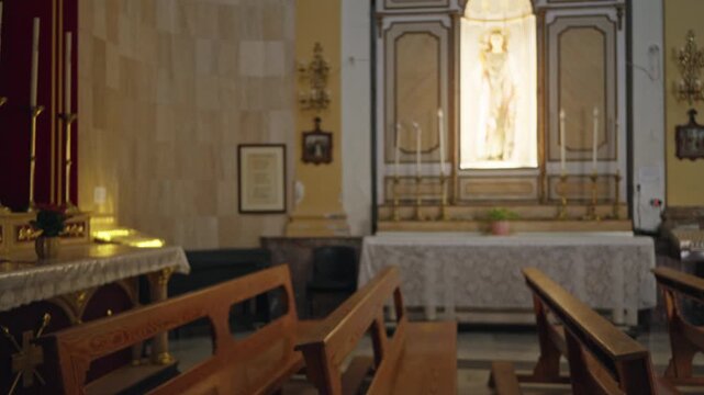 Blurred church interior with soft bokeh pews, altar and glowing candles, shallow defocused foreground and warm ambient nave lighting church; background backplate copyspace calm.