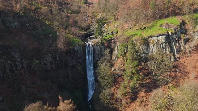 A drone rising pullout view of the Pistyll Rhaeadr waterfall in Powys, Wales, UK bringing the Berwyn moorland into view