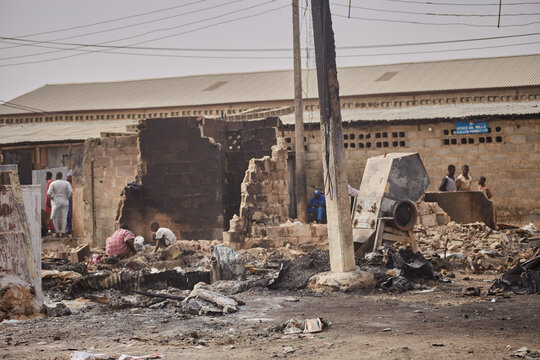 Kano, Nigeria - 27 January 2024: View of the charred remains of a building near Dakata fire service and Fatima market, a stark testament to a recent fire, with onlookers nearby.