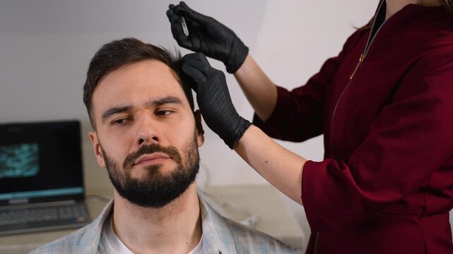 Trichologist injecting patient scalp for hair loss treatment