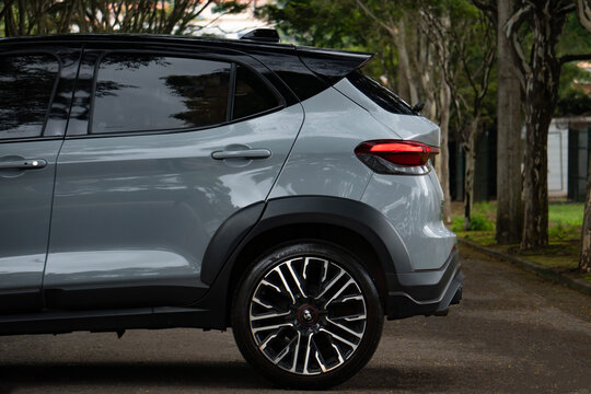 Gray Fiat Pulse Abarth rear end side view, sports crossover outdoors surrounded by green trees