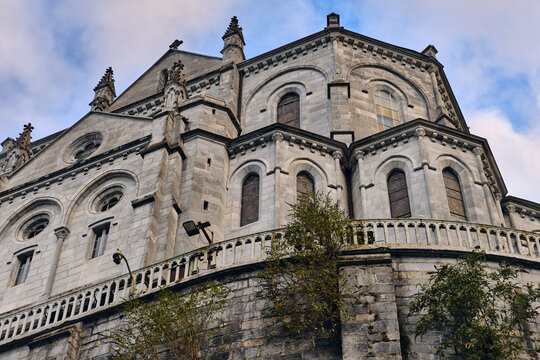 Lourdes, France - 19 November 2025: View of the striking Basilica of the Immaculate Conception, its stone facade rising majestically against a soft cloudy sky.