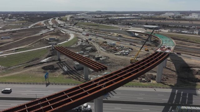 Denton, Texas USA &ndash; February 18, 2026: Aerial view of a highway interchange under construction with elevated ramps, bridge supports, and vehicle traffic on surrounding roadways.