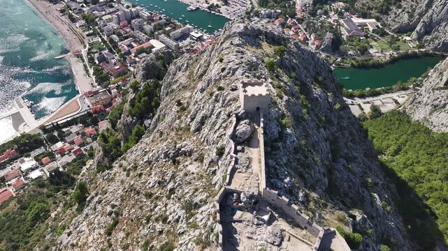 Detailed drone close up of Fortica fortress above Omi&scaron; showing historic stone structure on mountain ridge overlooking coastal landscape in Dalmatia Croatia