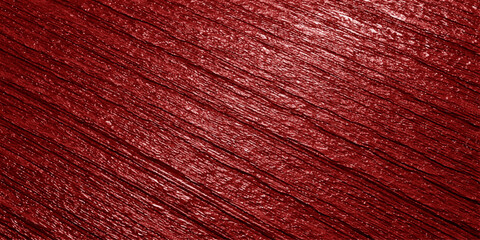 Fototapeta premium A close up view of a deep red surface featuring a rough diagonal texture and subtle light reflection