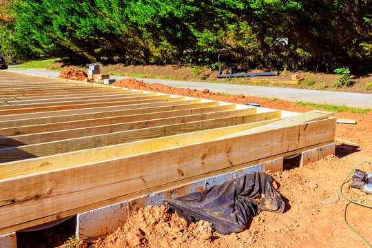 Construction of wooden deck frame takes place in residential area