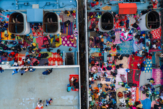 18 March 2026 - Dhaka, Bangladesh: Aerial view of passengers traveling home for Eid at Sadarghat Launch Terminal, resorting to traveling on the rooftops braving discomfort and danger.