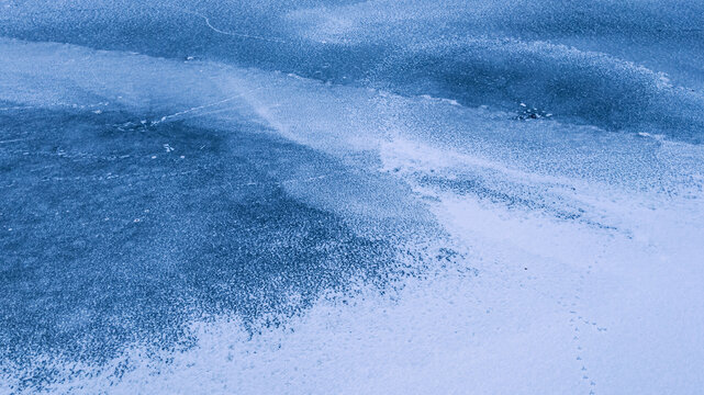 Cold natural scene featuring delicate bird steps over a partially frozen river 