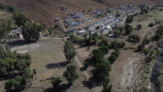 Camera panning up over the small residential neighborhood of the small historic village of Wupperthal. Wupperthal village is an isolated historical town in Cederberg known for whitewashed thatch roofs