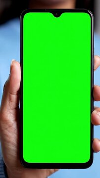Iphone Mockup, Hand holding a green-screen smartphone in a casual indoor setting, close-up view perfect for app presentation template showcase