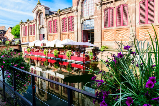 A restaurant with an outdoor patio beside a canal in Colmar, France.