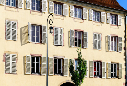 An old street lamp sits between old shutters on a building in Colmar, France.