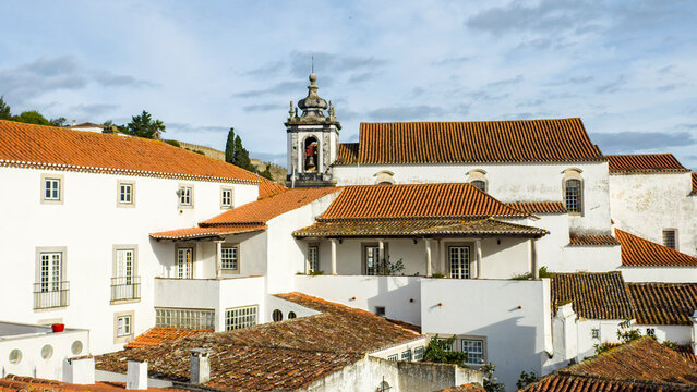 Tile rooftops in the walled city of Obidos and the bell tower of the Sao Tiago church, built by D. Sancho I in 1186. It was destroyed by the earthquake of 1755 and rebuilt in 1772.