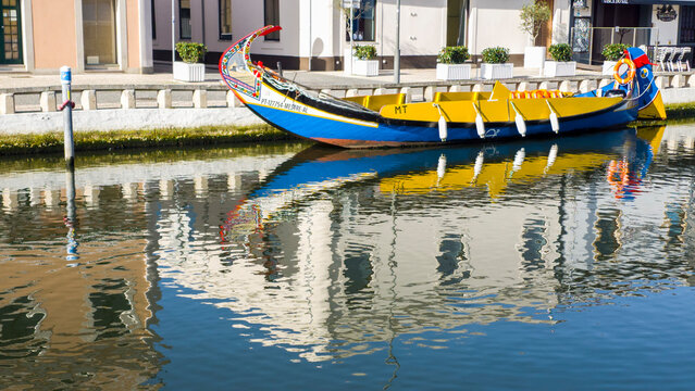 Europe, Portugal, Aveiro. Traditional Moliceiro boats along the Sao Roque Canal with reflections of the colorful houses.