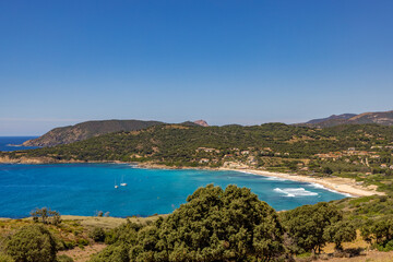Naklejka premium LA PLAGE DU PERU À CARGESE EN CORSE AVEC EN ARRIERE PLAN LE CAPO ROSSO