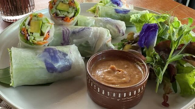 Dipping a Delicious Rice Paper Vegetable Roll in Peanut Sauce