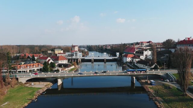 Aerial drone approach to road bridge over Elbe river with weir and town, Czech Republic