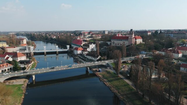 Aerial drone forward flight over Elbe river with road bridge, weir and Brand&yacute;s castle, Czech Republic