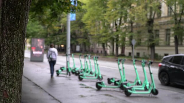 Electric scooters parked on a sidewalk in central Riga, Latvia. Micro mobility concept, blurred background. No recognizable people or logos.