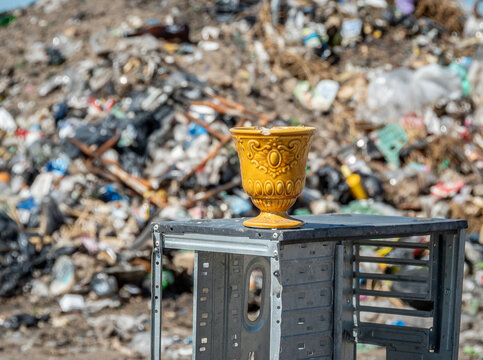 surrealismo , una copa de ceramica sobre un esqueleto de una computadora en un basurero , representando la curacion o sanacion 
