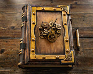 vintage leather book on the table with gears in central part of the cover