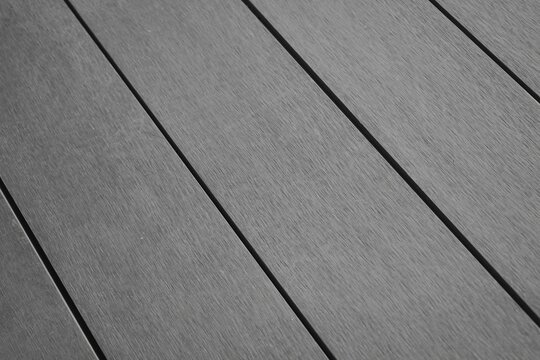 Grey composite wood decking planks in diagonal perspective view.