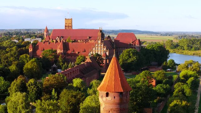Castle of the Teutonic Order in Malbork by the Nogat river at sunset. Poland