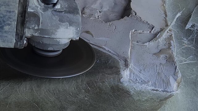 Close-up of a skilled artist using an angle grinder to cut and shape a fibre sculpture, captured in slow motion. The scene highlights precision craftsmanship, manual work, and industrial tools, India