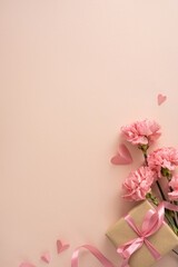 Fototapeta premium Happy Mother's Day vertical composition featuring pink carnations and a ribboned gift box with paper heart cutouts on a soft pastel background ideal for greeting cards and social posts