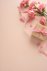 Happy Mother's Day  vertical flat lay featuring a pink carnation, ribbon-tied gift box and paper...