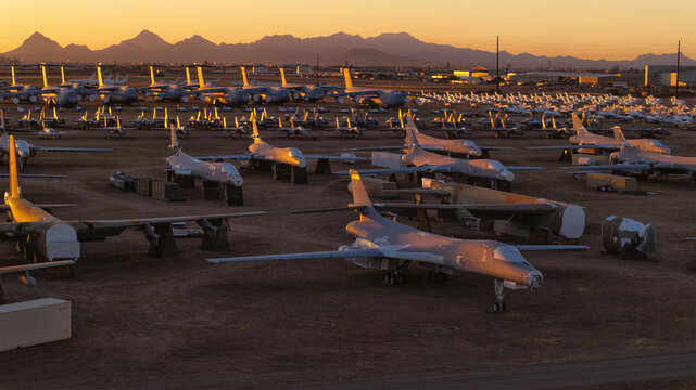 Tucson, United States - 06 February 2025: Aerial view of rows of retired aircraft gleaming under the warm glow of the setting sun at the Davis-Monthan Air Force Base's aircraft boneyard.