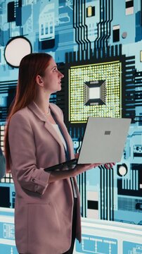 Vertical video Engineering team analyzing semiconductor fabrication with laptop, looking at display. Teamworking PCB factory colleagues oversee microprocessor production with notebook, camera A