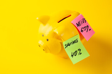 Piggy bank with sticky notes on a yellow background, saving money concept
