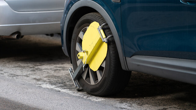 Car wheel locked with parking clamp for illegal parking
