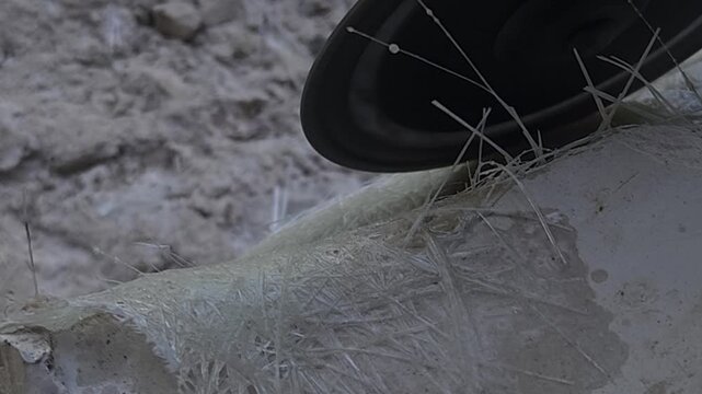 Close-up of a skilled artist using an angle grinder to cut and shape a fibre sculpture, captured in slow motion. The scene highlights precision craftsmanship, manual work, and industrial tools, India