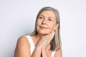Portrait of beautiful senior woman on light background
