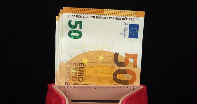 Euro banknotes. 50 euro banknotes in a red wallet. Cash, finance, savings, wealth. European Union money, EUR. 250 Euros in five 50 euro banknotes