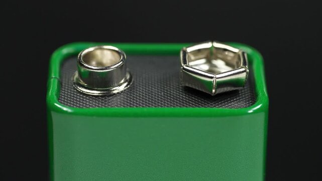 Nine-volt battery with terminals. Nine-volt battery, or 9-volt battery, is an electric battery that supplies a nominal voltage of 9 volts. Green 9-volt battery ready to power devices