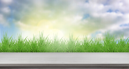 Fototapeta premium Green spring grass and wooden table under beautiful sky. Banner design
