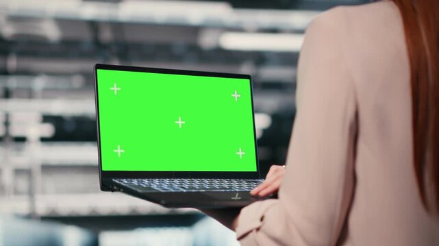 Green screen mockup laptop, machines and worker in server hub doing maintenance tasks. configuring settings, chroma key isolated screen notebook and IT expert in modern data center, camera B