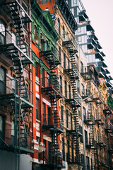 Obraz premium Fire escape stairs on building facade in New York, low angle view